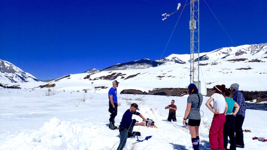 A group of researchers at a snowy flux tower site.